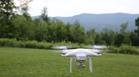 A drone or quadcopter hovering and taking off in a backyard surrounded by Stock Footage 66248787