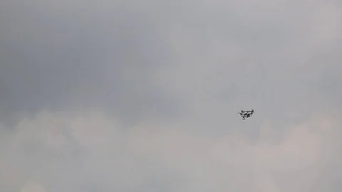 Drone or quadrocopter flying in the sky on a cloudy summer day. Robot and Stock Footage 76973906