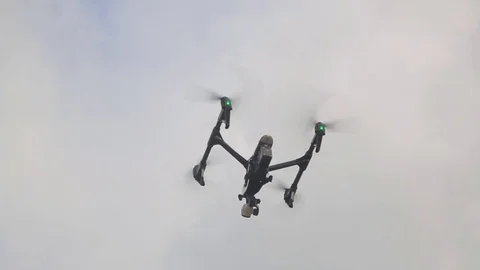 Drone or quadrocopter flying in the sky on a cloudy summer day. Robot and Stock Footage 76973913