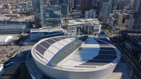 Drone orbit around Crypto arena roof name and solar panels toward L.A. Live. Vídeos de archivo 347341920