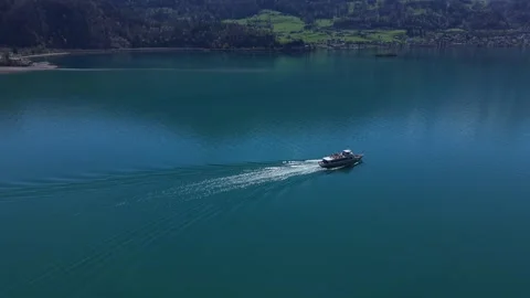 Drone orbit around ferry on alpine lake Видео 332370677