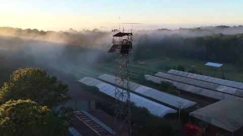 Drone orbit around forestry research tower and greenhouses in morning radiation Stock Footage 342226571