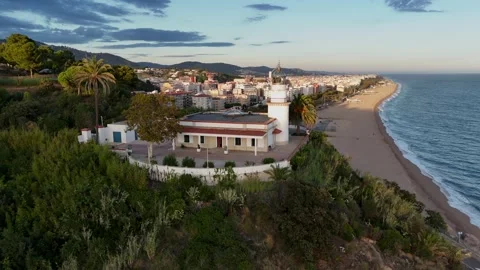 Drone Orbit Around Lighthouse Overlooking City and Beach, Costa Brava Stock Footage 319861115