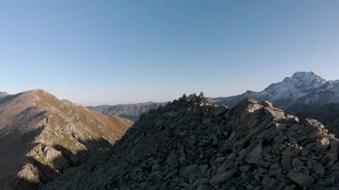 Drone orbit around mountain ridge with huge snow covered peak on the horizon Stock Footage 313740853