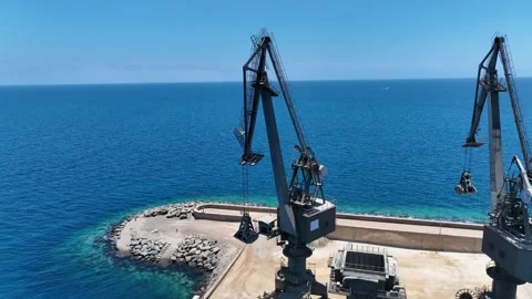 Drone Orbit Around Rugged Cranes with Stunning Ocean and Sky Backdrop Stock Footage 310143282