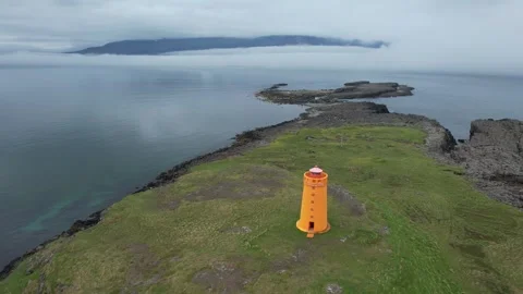 Drone orbit around small orange lighthouse above fjord at Hafnarnes, Iceland Stock Footage 346552046