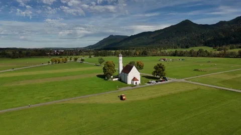 Drone orbit around St. Coloman Church in green valley with Alps in background Stock Footage 319789756