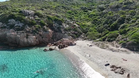 Drone Orbit Around Towering Green Rocky Mountain and Turquoise Beach in Vídeo Stock 334342259
