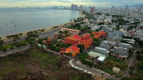 Drone orbit over coastal temple with Da Nang skyline and beach at sunrise Stock Footage 340597562