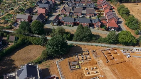 Drone orbit over construction site with new housing estate behind, suburban 動画素材 345669427