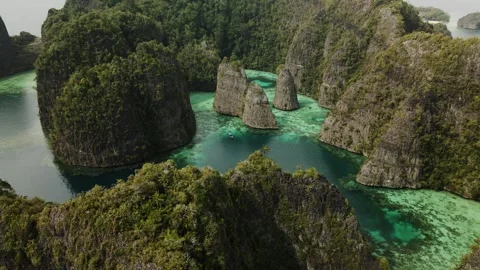 Drone orbit shot around a cliffs, turquoise water in Raja Ampat 스톡 동영상 260023029