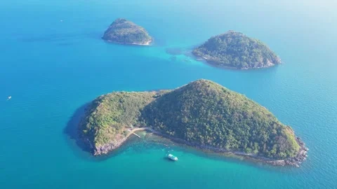 Drone orbit shot circling three tropical islands in emerald sea water 4K Stock Footage 333938994