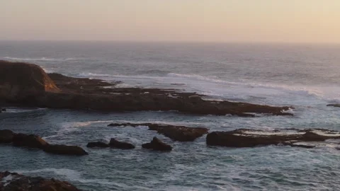 Drone orbit of waves crashing along rocky sea stacks off Highway 1 in California Stock Footage 295265431