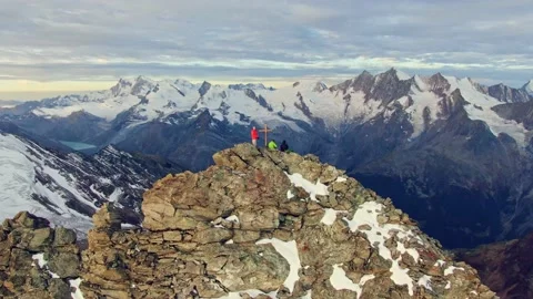 Drone orbiting around 3 hikers on the summit of Lagginhorn, Switzerland Stock Footage 133337436