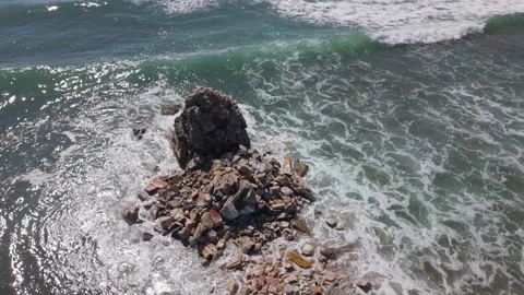 Drone Orbiting Close to Crumbled Beacon in Shallow Sea with Waves Crashing Again Stock Footage 306316991