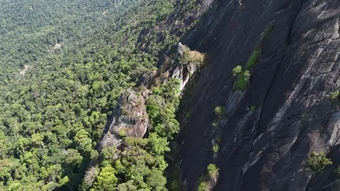 Drone orbiting sharp rocky pinnacle beside giant boulder on mountain 動画素材 336956638