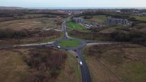 Drone orbiting UK roundabout with traffic Stock Footage 328125669