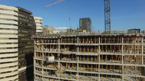 Drone orbits around building under construction in the middle of a city Stock Footage 64125185