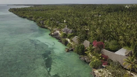 Drone orbits around seaside resort next to turquoise waters on a sunny day Stock-Footage 346480242