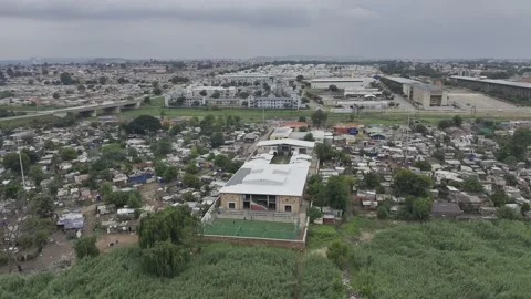 Drone orbits Kliptown youth program center on overcast day in Soweto Stock Footage 324650613