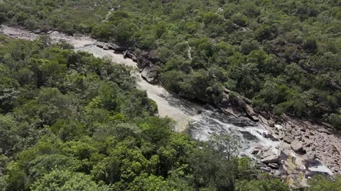 Drone orbits to the left around natural pool and waterslide Stock Footage 276343927