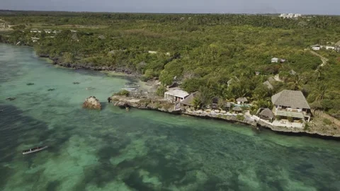 Drone orbits left over crystal clear waters next to seaside resort Stock-Footage 346480795