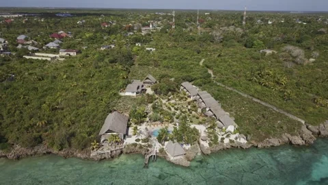 Drone orbits over sea around coastal resort deep in forest on a sunny day Stock-Footage 346471099