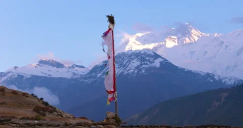 Drone orbits prayer flag pole with Annapurna II in background in Annapurna Stock Footage 342001326