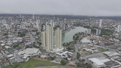 Drone orbits to right high over Açude Velho on cloudy day in Campina Grande Stock Footage 279126547