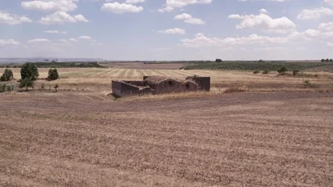 Drone over ancient building ruins in the middle of a farmer's field on a cloudy Stock Footage 279070989