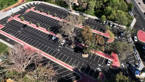 A drone over a city park with trees and a parking area for cars. Sunny summer Stock Footage 310236414