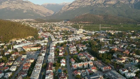 Drone over a city surrounded by mountains at dawn, summer day 4k Stock Footage 217888882