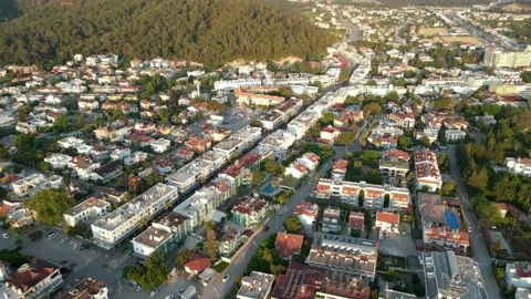 Drone over a city surrounded by mountains at dawn, summer day 4k Stock Footage 217889976