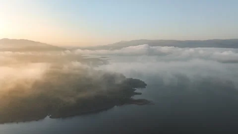 Drone over clouds, lake, and sunrise Stock Footage 296790602