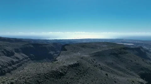 Drone Over Dramatic Green Mountains and Valleys with Clear Blue Sky Stock Footage 309943582