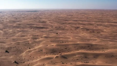 A drone over a group of tourists walking along the desert sand dune. Dubai, a Stock Footage 310296929