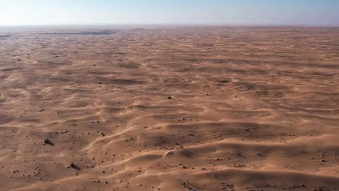 A drone over a group of tourists walking along the desert sand dune. Dubai, a Stock Footage 311804922