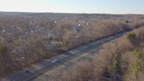 Drone over highway low sun fall trees town 스톡 동영상 104807518