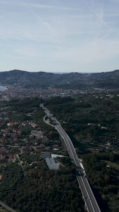 Drone over the highway that runs between the forest trees near the mediterranean Stock Footage 280011955