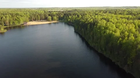 Drone Over a Lake With Dark Blue Water Along the Forest to the Beach Stock Footage 134060239