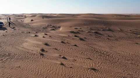 A drone over a lone man walking on a sand dune in the desert. Dubai, a sunny Stock Footage 278872088