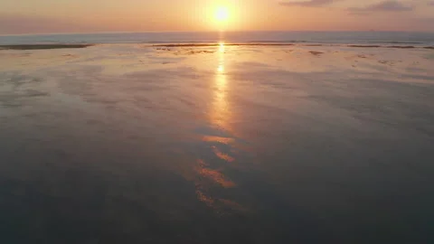 Drone Over Low Tide Beach Towards Sunrise Over Sea Stock Footage 146102908