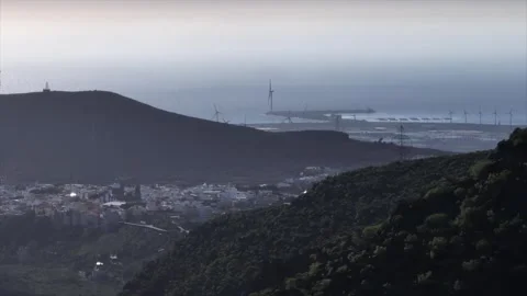 Drone Over Lush Mountainside with Distant Coastline Under Grey Sky Stock Footage 309949191