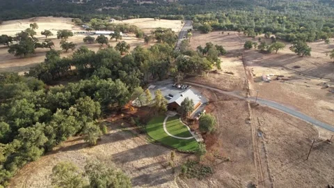 Drone Over Lush Roadside Barn Property With Distant Hills (2 of 2) Stockbeeldmateriaal 166319631