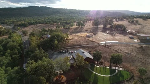 Drone Over Lush Roadside Barn Property With Distant Hills (1 of 2) Stockbeeldmateriaal 166319640