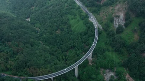 A drone over a mountain road in dense forest and fog. Cloudy summer day Stock Footage 309086950