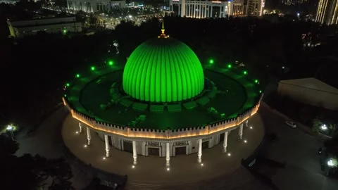 A drone over a museum in the middle of a night city lit up by lights. Cloudless Stock Footage 310248093