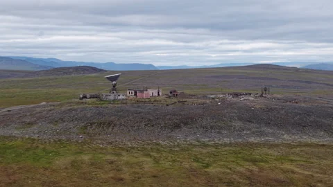 Drone over Orbita station ruins above Lavrentiya, Chukotka tundra coast Stock Footage 327121780