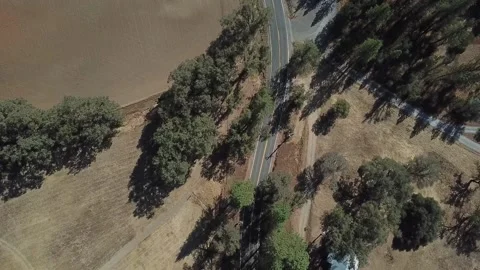 Drone Over Passing Car Through Field With Roadside Barn Stockbeeldmateriaal 166320452