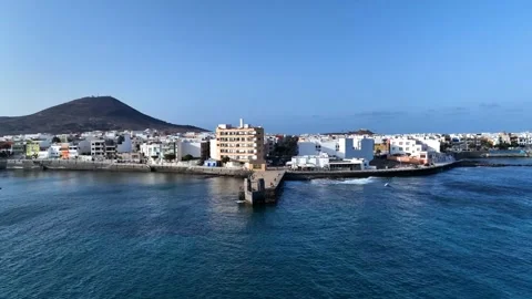 Drone over Playa de Arinaga coastal village with pier and blue ocean Stock Footage 310683477